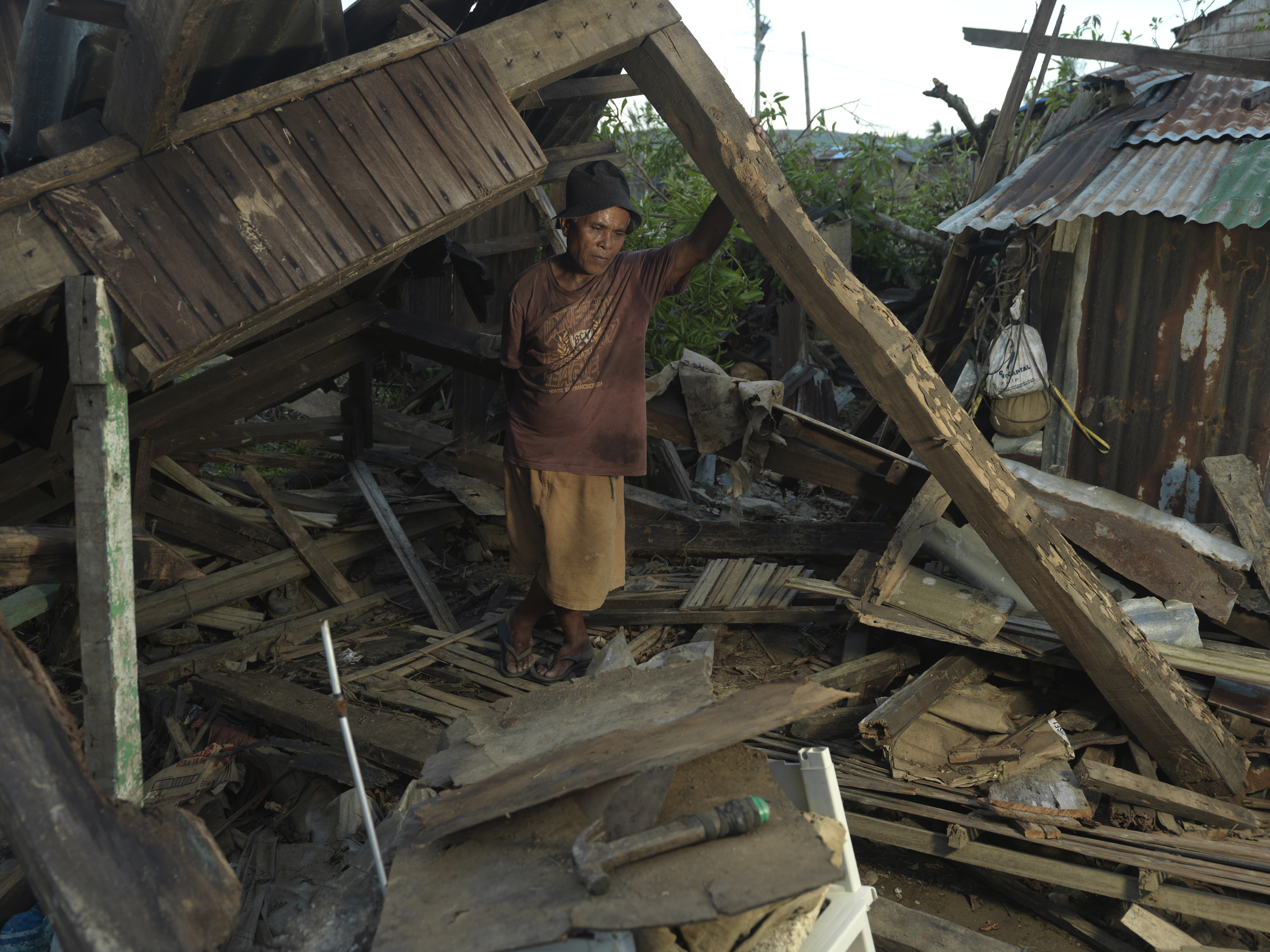 An older man shows the rubble of house destroyed in Typhoon Haiyan.