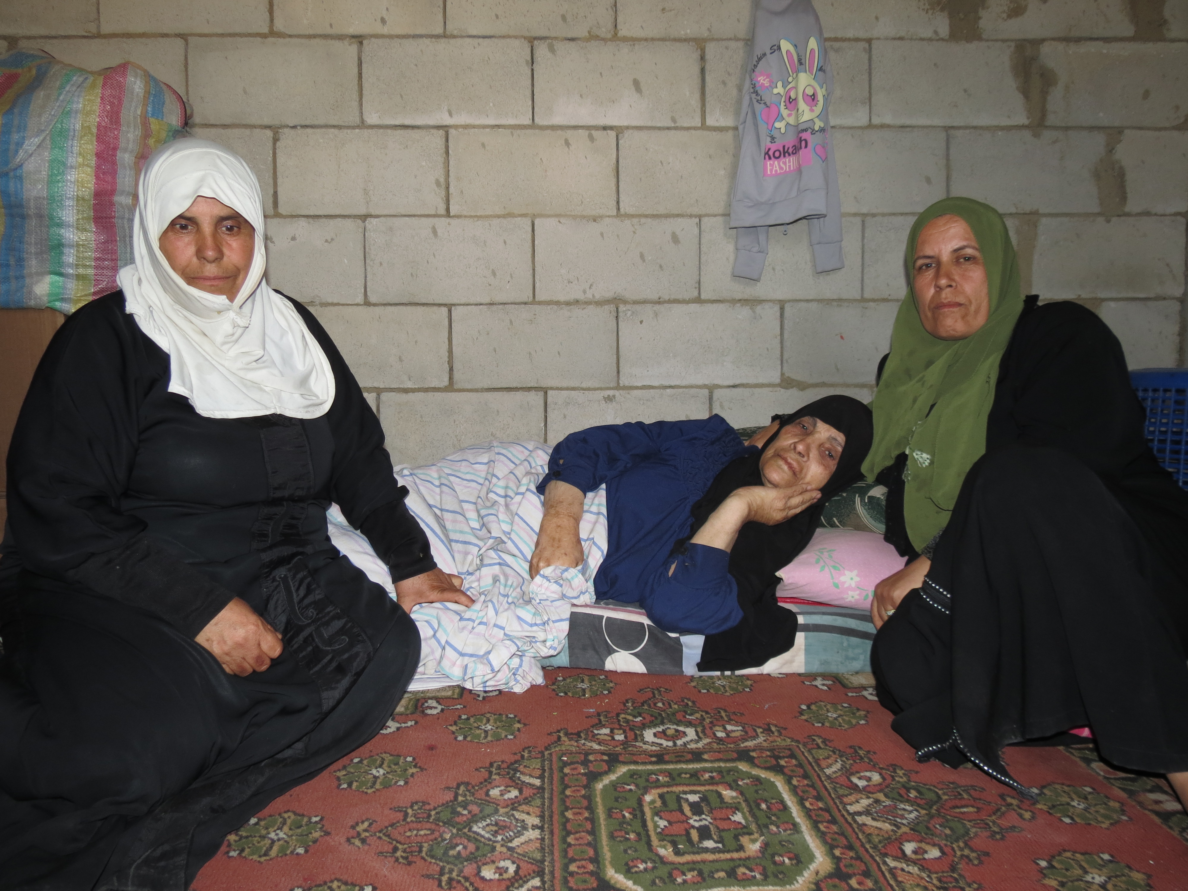 An older Syrian refugee is bed bound due to injuring her legs.