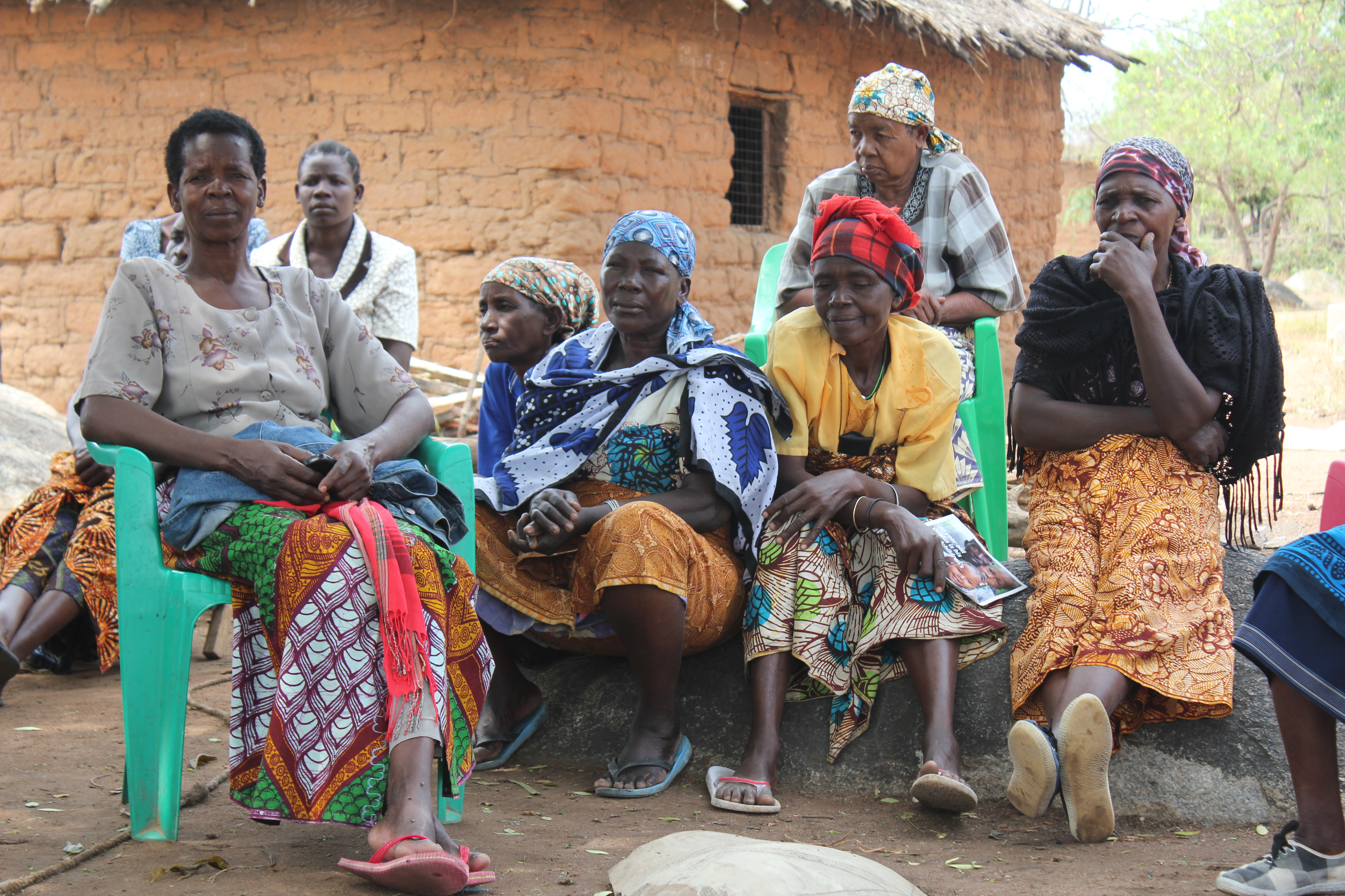 A group of older women sit and listen in training class