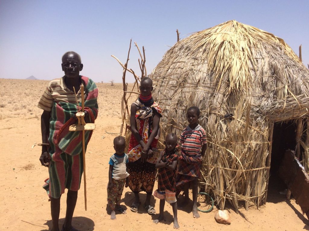 A family stands outside their house during the East Africa Drought.