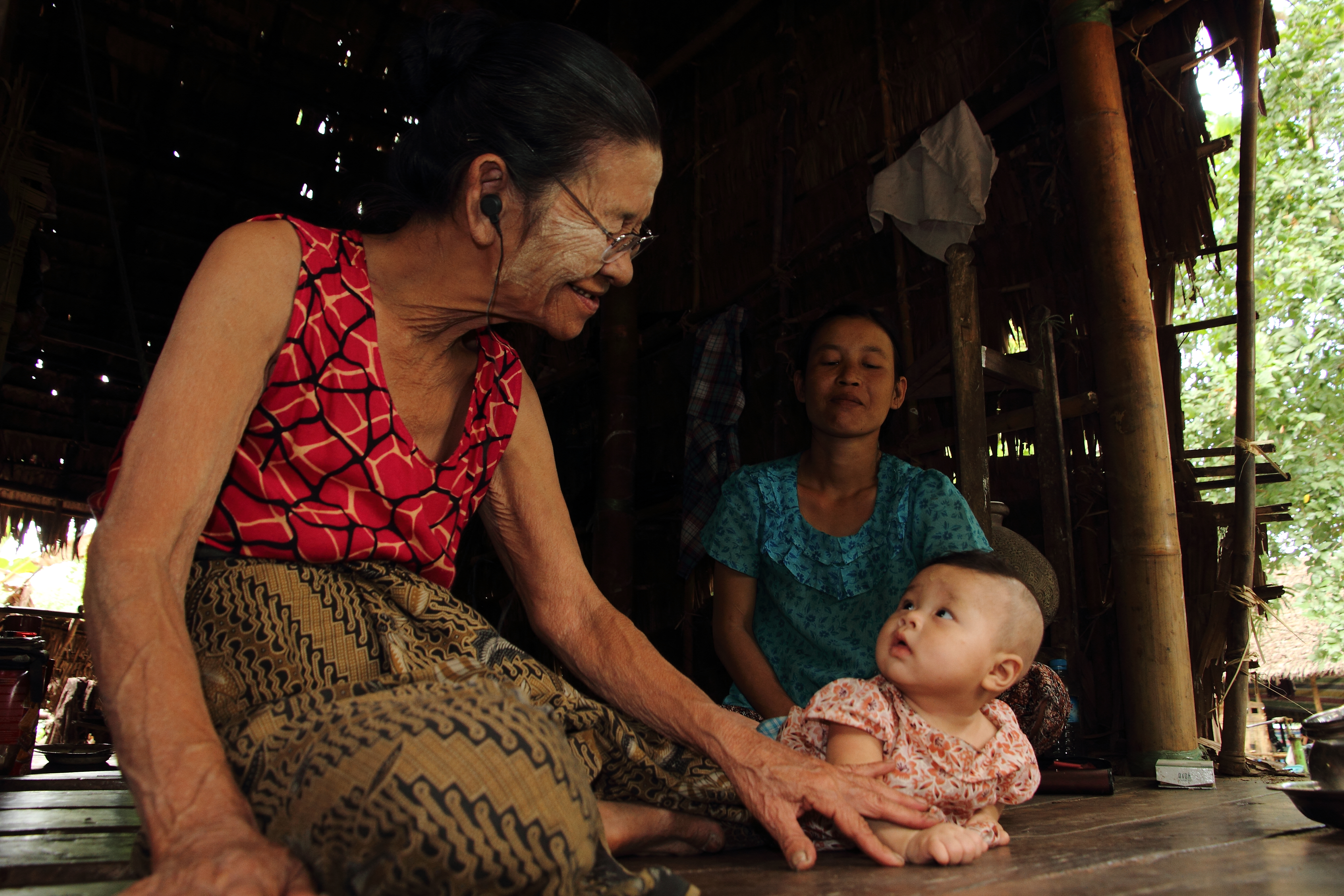 AN older woman in Myanmar plays with her grandchild.